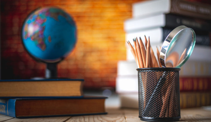 Desk with pens, books and a globe