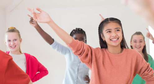 Students practice their social skills with each other while learning a new dance move.