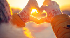 Image of someone making a heart with the sunset shining through