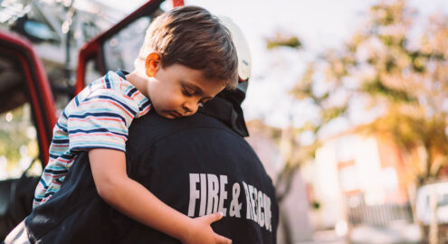 Firefighter carrying little boy after successful rescue operation