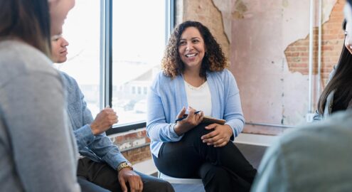 Woman in blue sweater connects with colleagues who are different from her.