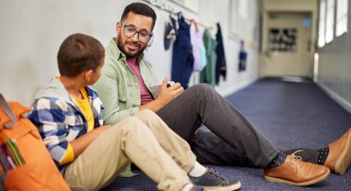 Teacher talking to young sad student